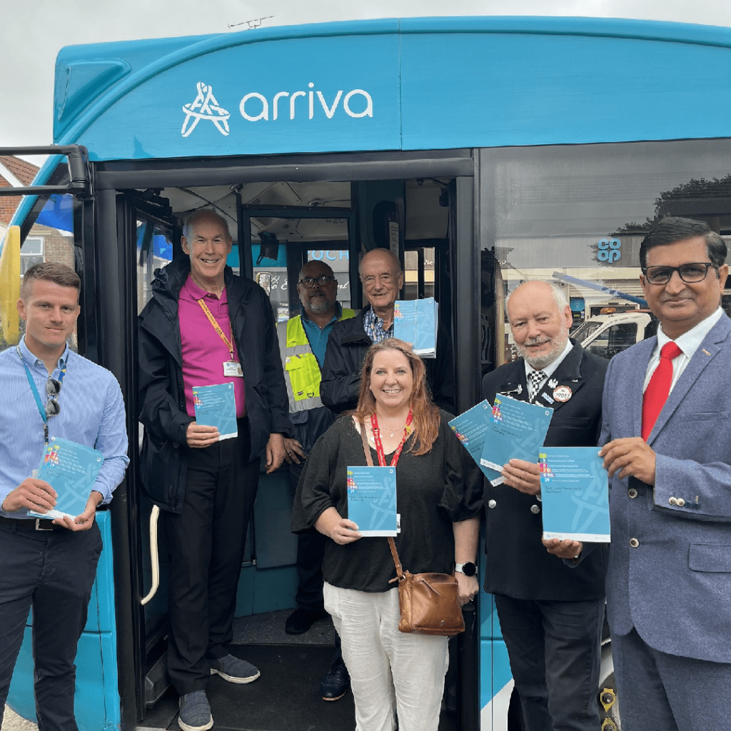 Several local councillors posing with Arriva bus and holding bus time tables.